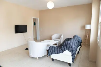 a living room with a table and chairs and a tv at Airport city center in Spáta