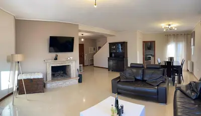 a living room with a couch and a fireplace at Serenity Residence in Anavissos