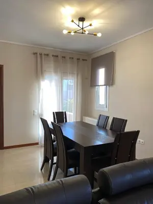 a dining room with a black table and chairs at Serenity Residence in Anavissos