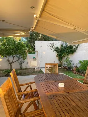 a wooden table and chairs under a patio umbrella at Serenity Residence in Anavissos