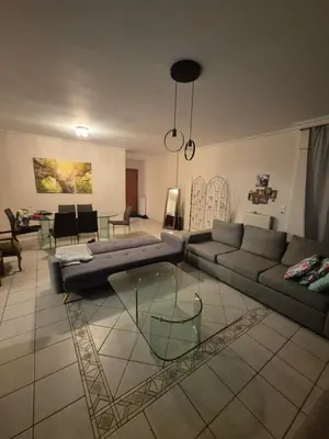 a living room with a couch and a glass table at ATHEN'S riviera apartment Acropolis view in Athens