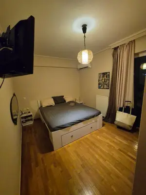 a bedroom with a bed and a flat screen tv at ATHEN'S riviera apartment Acropolis view in Athens