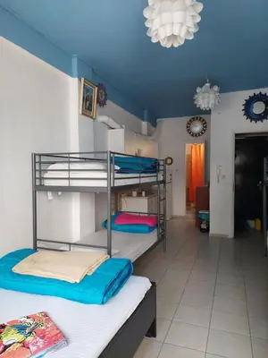 a room with three bunk beds and a living room at Acropolis views in Monastiraki square in Athens