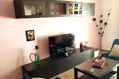 a living room with a television and a table at Comfortable Apartment in the Center of Piraeus in Piraeus