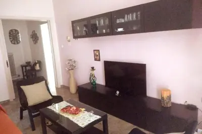 a living room with a couch and a tv and a table at Comfortable Apartment in the Center of Piraeus in Piraeus