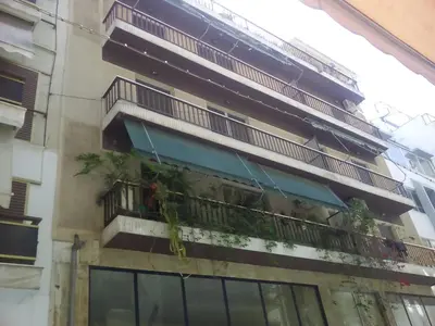 a building with a balcony with plants on it at Comfortable Apartment in the Center of Piraeus in Piraeus