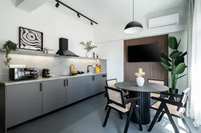 a kitchen with a table and chairs and a tv at ATELIER 64 , Monastiraki Apartments & Suites in Athens