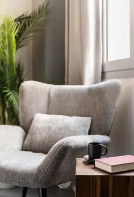 a chair with a cup of coffee and a book on a table at ATELIER 64 , Monastiraki Apartments & Suites in Athens