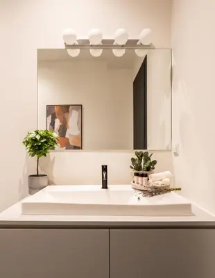a bathroom with a white sink and a mirror at ATELIER 64 , Monastiraki Apartments & Suites in Athens