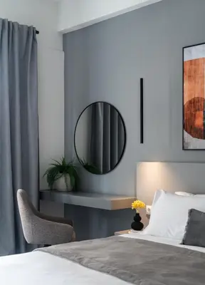 a bedroom with a bed with a mirror and a chair at ATELIER 64 , Monastiraki Apartments & Suites in Athens