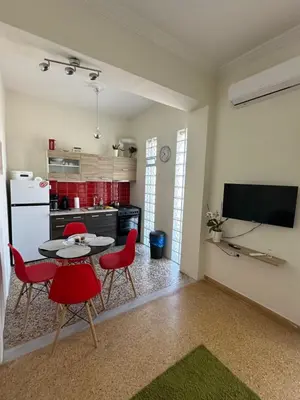 a kitchen with a table and red chairs in a room at Aegean Light Flat near Metro in Athens