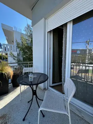 a patio with a table and chairs on a balcony at Aegean Light Flat near Metro in Athens