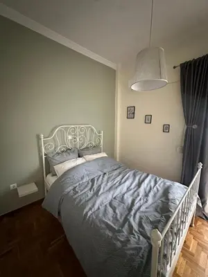 a bedroom with a bed with a blue comforter at Aegean Light Flat near Metro in Athens
