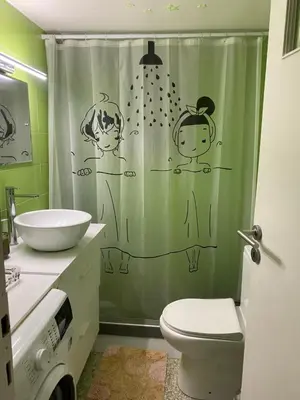 a bathroom with a shower curtain with people on it at Aegean Light Flat near Metro in Athens