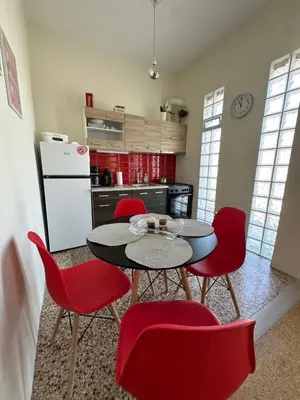 a kitchen with a table and red chairs at Aegean Light Flat near Metro in Athens