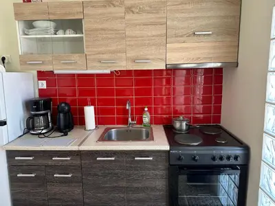 a small kitchen with a sink and red tiles at Aegean Light Flat near Metro in Athens