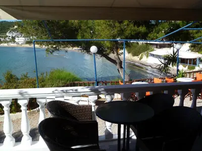 a balcony with chairs and a view of a beach at Liberty II in Agia Marina Aegina