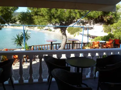 a balcony with chairs and a view of a beach at Liberty II in Agia Marina Aegina