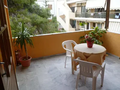 a patio with a table and chairs on a balcony at Liberty II in Agia Marina Aegina