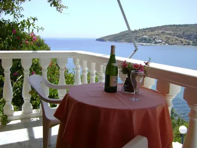 a bottle of wine sitting on a table on a balcony at Liberty II in Agia Marina Aegina