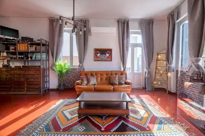 a living room with a couch and a table at The Industrial Loft - Private Rooftop & Jacuzzi in Athens
