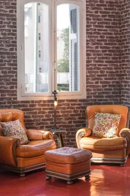 two leather chairs and a stool in a room at The Industrial Loft - Private Rooftop & Jacuzzi in Athens