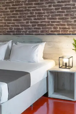 a bedroom with a bed and a brick wall at The Industrial Loft - Private Rooftop & Jacuzzi in Athens