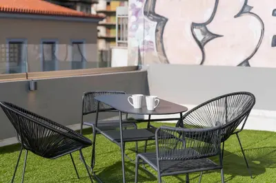 a table and chairs sitting on a balcony at The Industrial Loft - Private Rooftop & Jacuzzi in Athens
