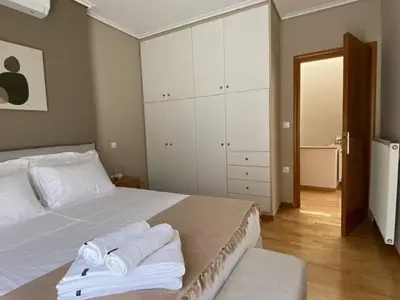 a bedroom with a white bed with towels on it at Elegant, villa with pool in Athens Riviera in Athens