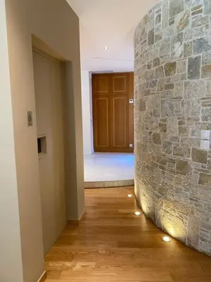 a hallway with a stone wall and a door at Elegant, villa with pool in Athens Riviera in Athens