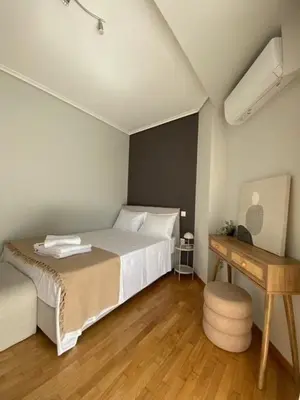 a bedroom with a white bed and a wooden floor at Elegant, villa with pool in Athens Riviera in Athens