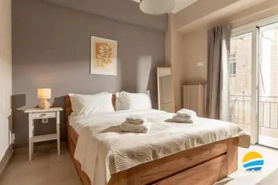 a bedroom with a bed with towels on it at Pame Rentals - 2BD Modern Home Steps from Pasalimani in Piraeus