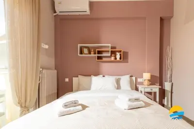 a bedroom with a bed with towels on it at Pame Rentals - 2BD Modern Home Steps from Pasalimani in Piraeus