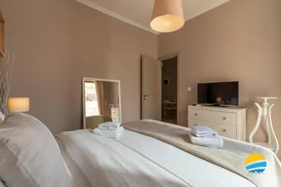 a bedroom with a bed and a tv in it at Pame Rentals - 2BD Modern Home Steps from Pasalimani in Piraeus