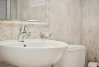 a bathroom with a white sink and a toilet at One-Bedroom Jacuzzi Glyfada in Athens