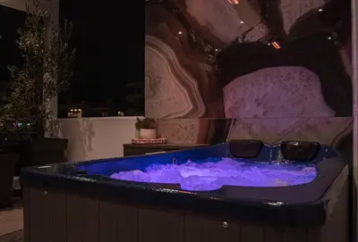a jacuzzi tub with blue lighting in a room at One-Bedroom Jacuzzi Glyfada in Athens