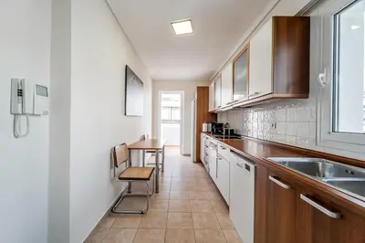 a kitchen with white cabinets and a table and chairs at 2bedroom Apartment in Glyfada in Athens