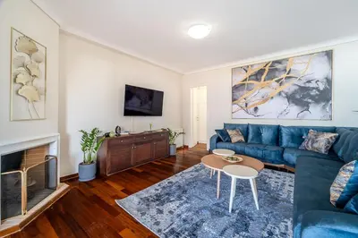 a living room with a blue couch and a fireplace at 2bedroom Apartment in Glyfada in Athens