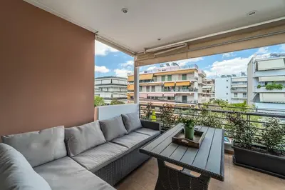 a living room with a couch and a table on a balcony at 2bedroom Apartment in Glyfada in Athens