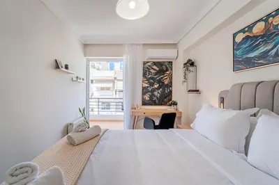 a bedroom with a large white bed and a desk at 2bedroom Apartment in Glyfada in Athens