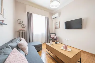 a living room with a blue couch and a table at Ble Elia Karyatis Suite in Athens
