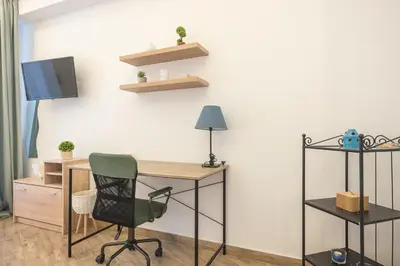 an office with a desk and a chair and a tv at Ble Elia Karyatis Suite in Athens