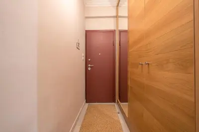 a corridor with a red door in a room at Ble Elia Karyatis Suite in Athens