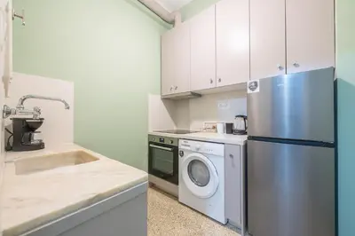 a kitchen with a refrigerator and a washing machine at Ble Elia Karyatis Suite in Athens