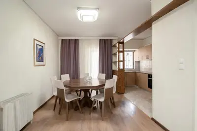 a kitchen and dining room with a table and chairs at FilOikos Veranda Deck Escape and Retreat 3Br 2Ba in Athens