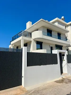 a white house with a black fence at CasaMare Lagonisi Athens Riviera Luxury modern villas apartment's in Lagonissi