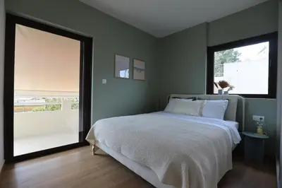 a bedroom with a bed and a large window at Modern Coastal Voula Flat in Athens