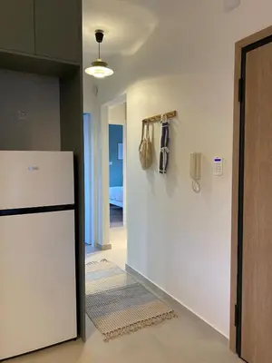 a kitchen with a white refrigerator and a hallway at Modern Coastal Voula Flat in Athens