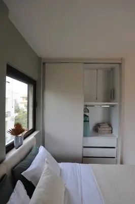 a bedroom with a white bed and a window at Modern Coastal Voula Flat in Athens