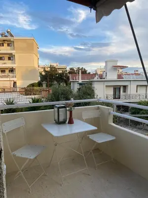 a white table and two chairs on a balcony at Modern Coastal Voula Flat in Athens
